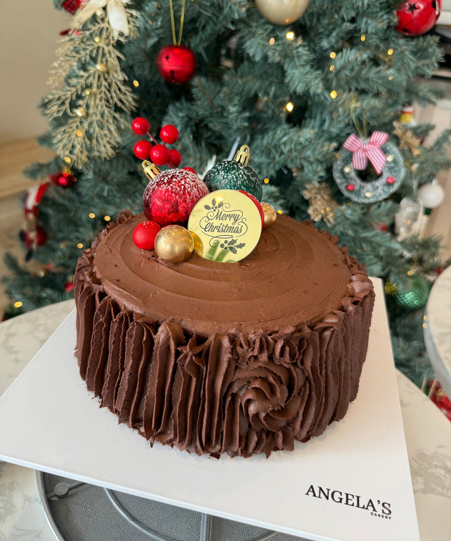 Chocolate cake with a Christmas tree in the background
